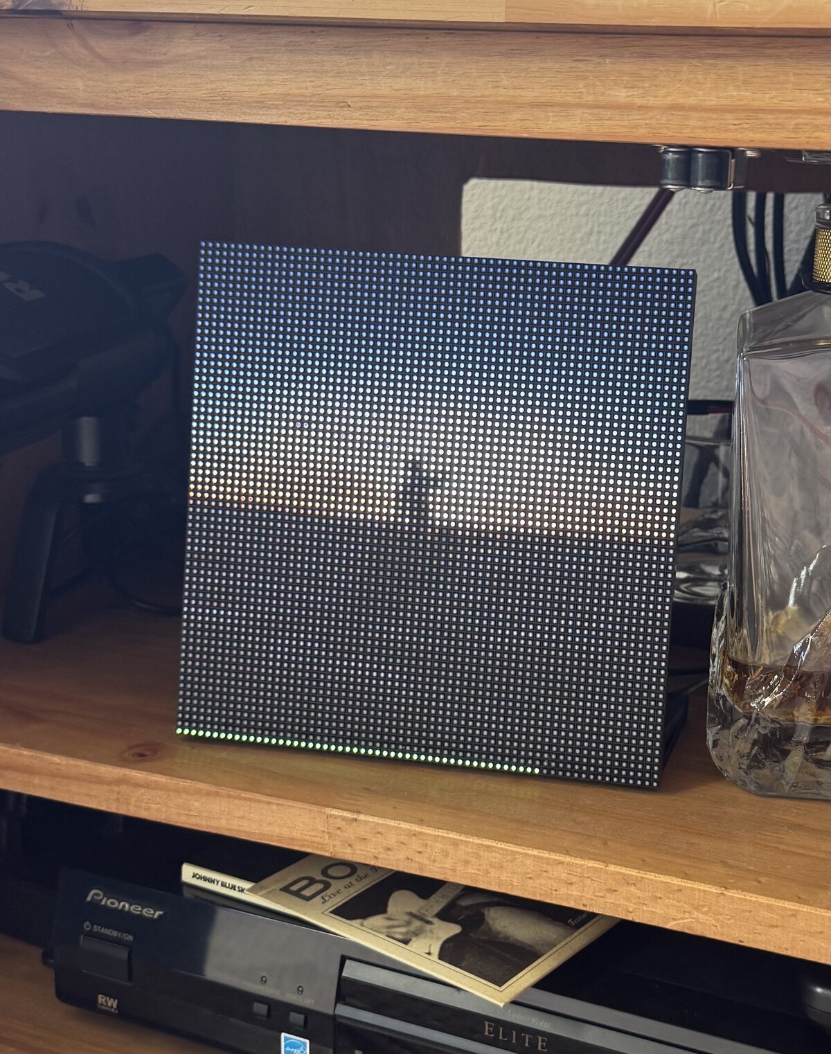Vinyltron showing album art with a progress bar, Pioneer receiver and decanter visible on the shelf